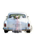 White vintage wedding car rear adorned with custom floral garland and pink ribbon set for bridal decoration