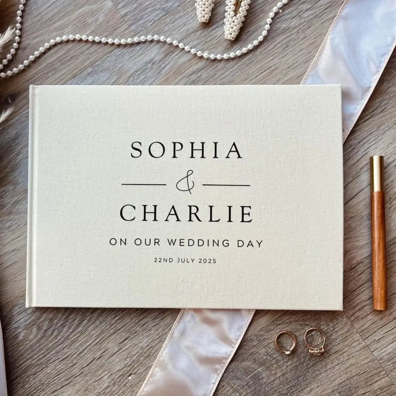 Beige linen textured custom wedding guest book with black serif lettering for sophia and charlie 22nd july 2025