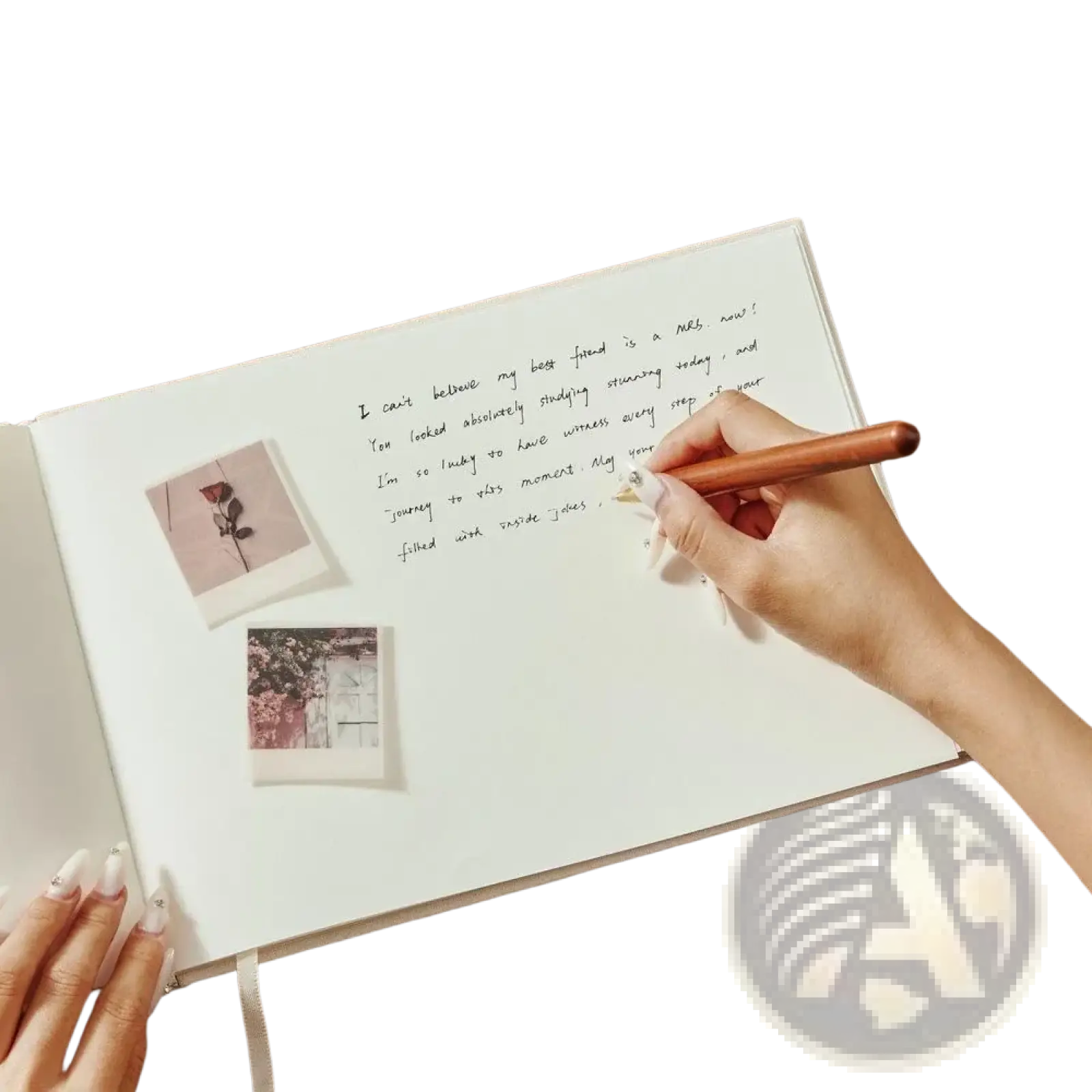 A hand holds a wooden pen writing in a white linen custom wedding guest book with pinned photo album pages