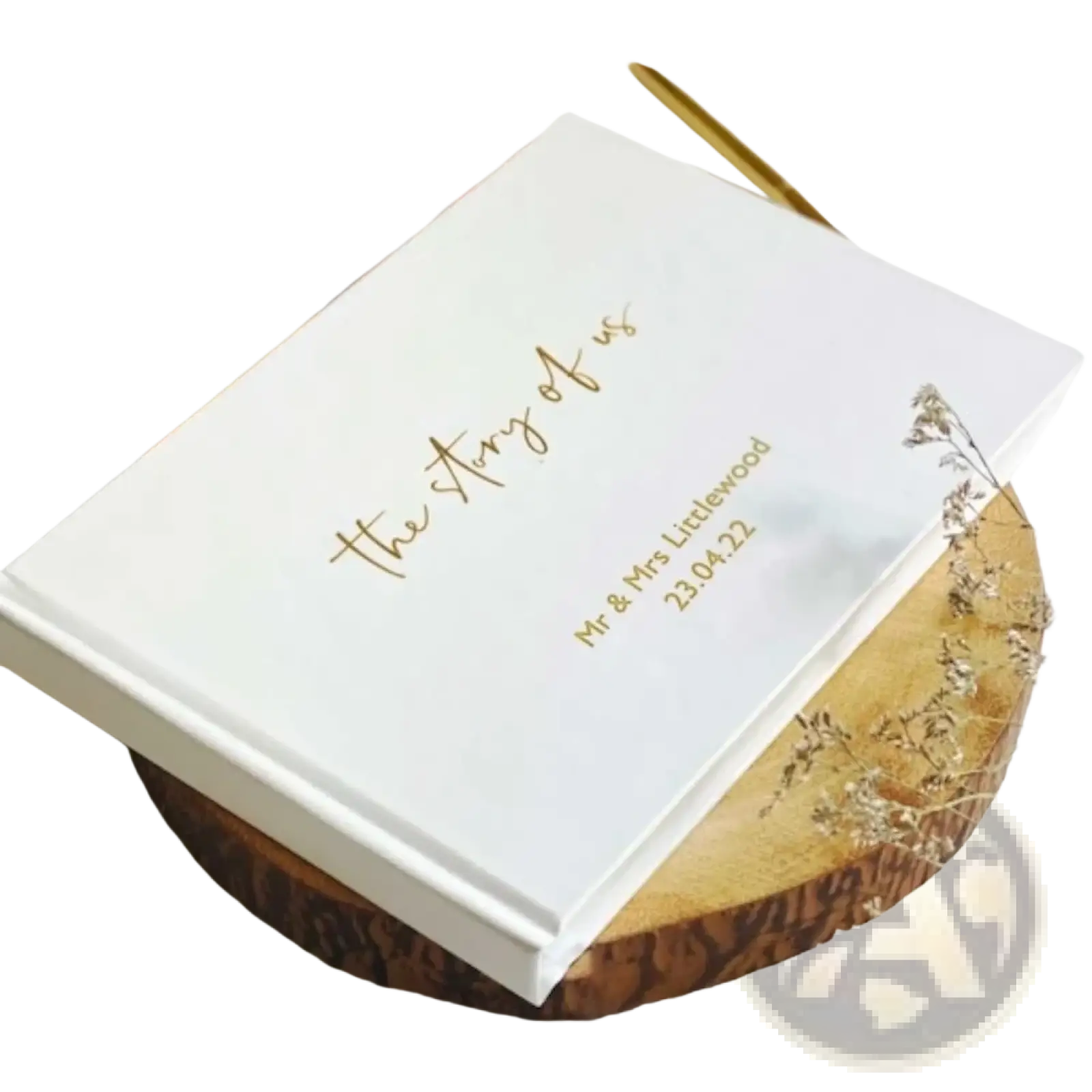 Custom wedding guest book with white hardcover and gold foil lettering resting on wooden slice for keepsake use
