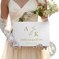 Custom wedding guest book in white with gold foil lettering and a delicate floral design between initials a and k