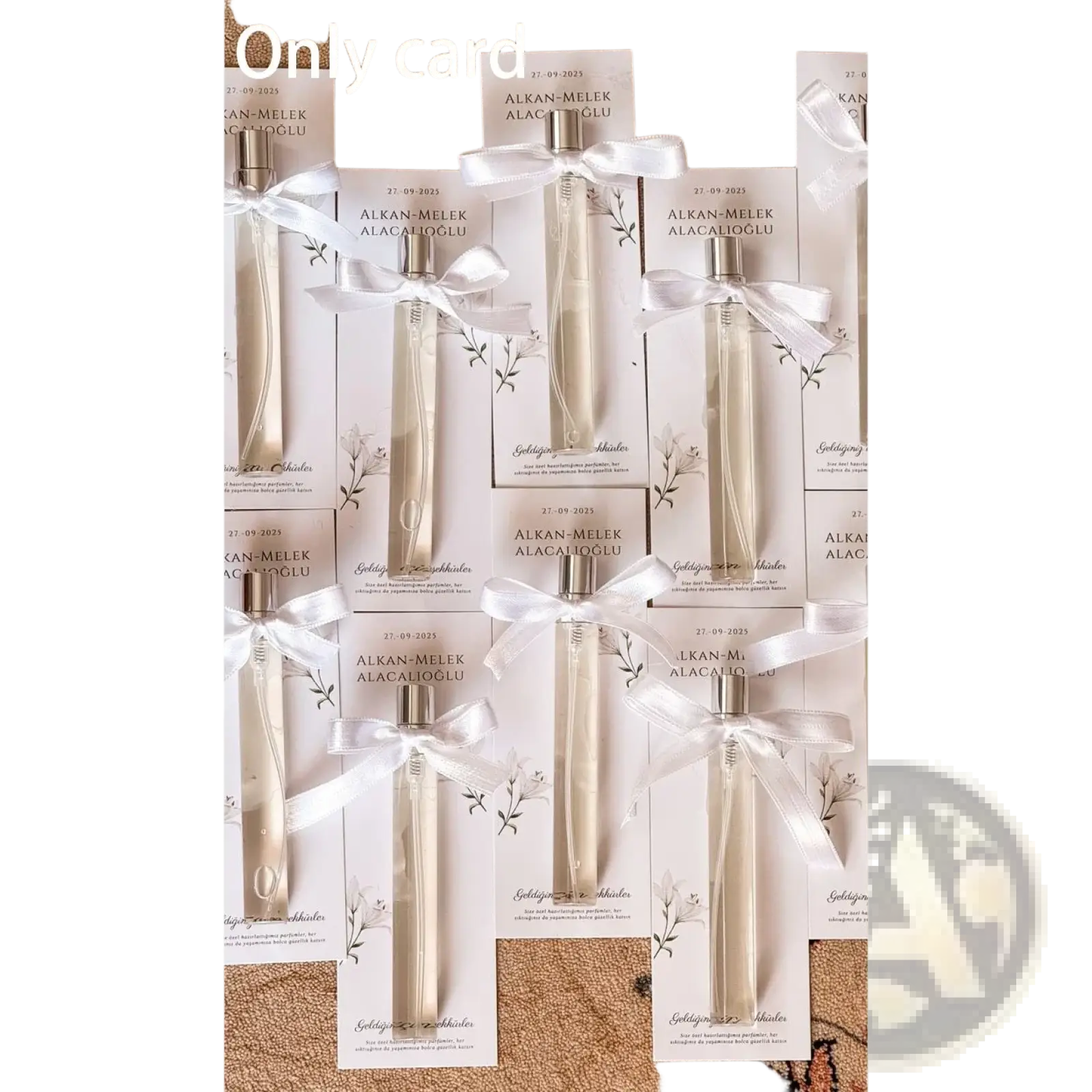 Elegant cream-colored glass diffuser bottles with silver caps in white cardboxes tied with satin ribbons for wedding favors