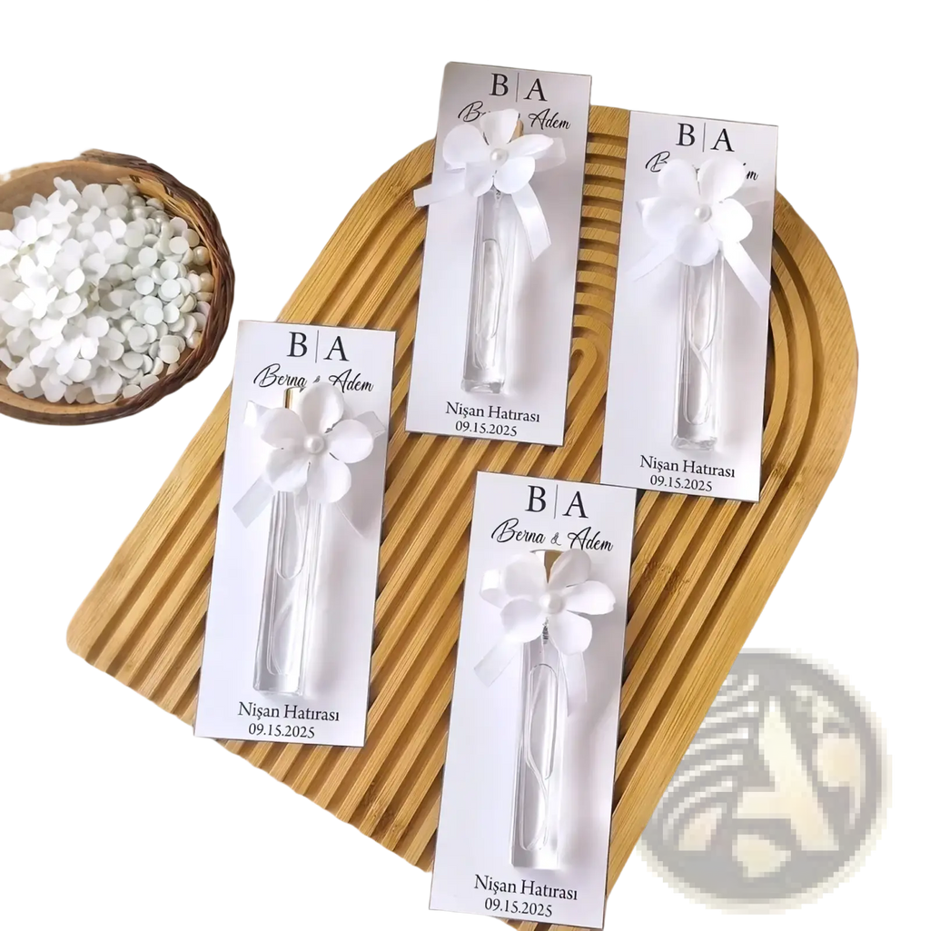 Custom white floral-themed wedding perfume favor bottles with personalized gift cards and ribbon ties for elegant presentation