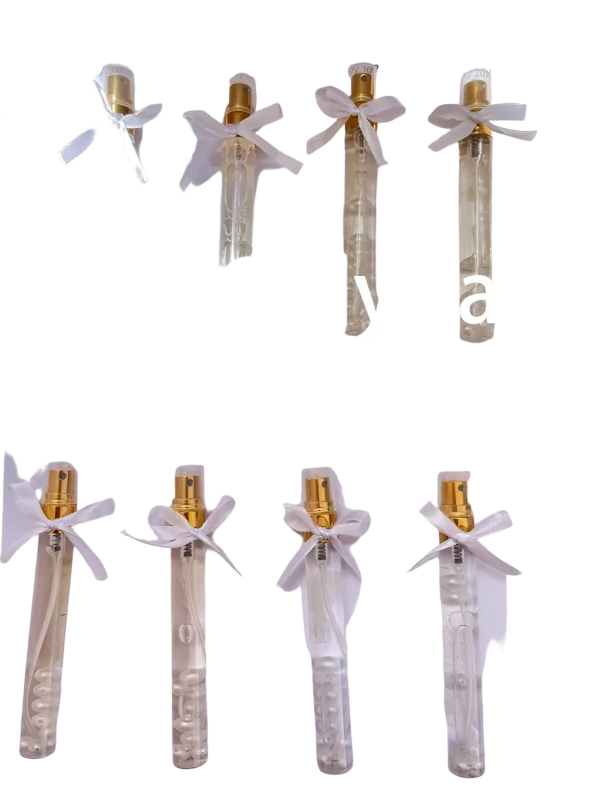 Clear glass custom wedding perfume gift vials with gold spray nozzles and white ribbons tied around the neck