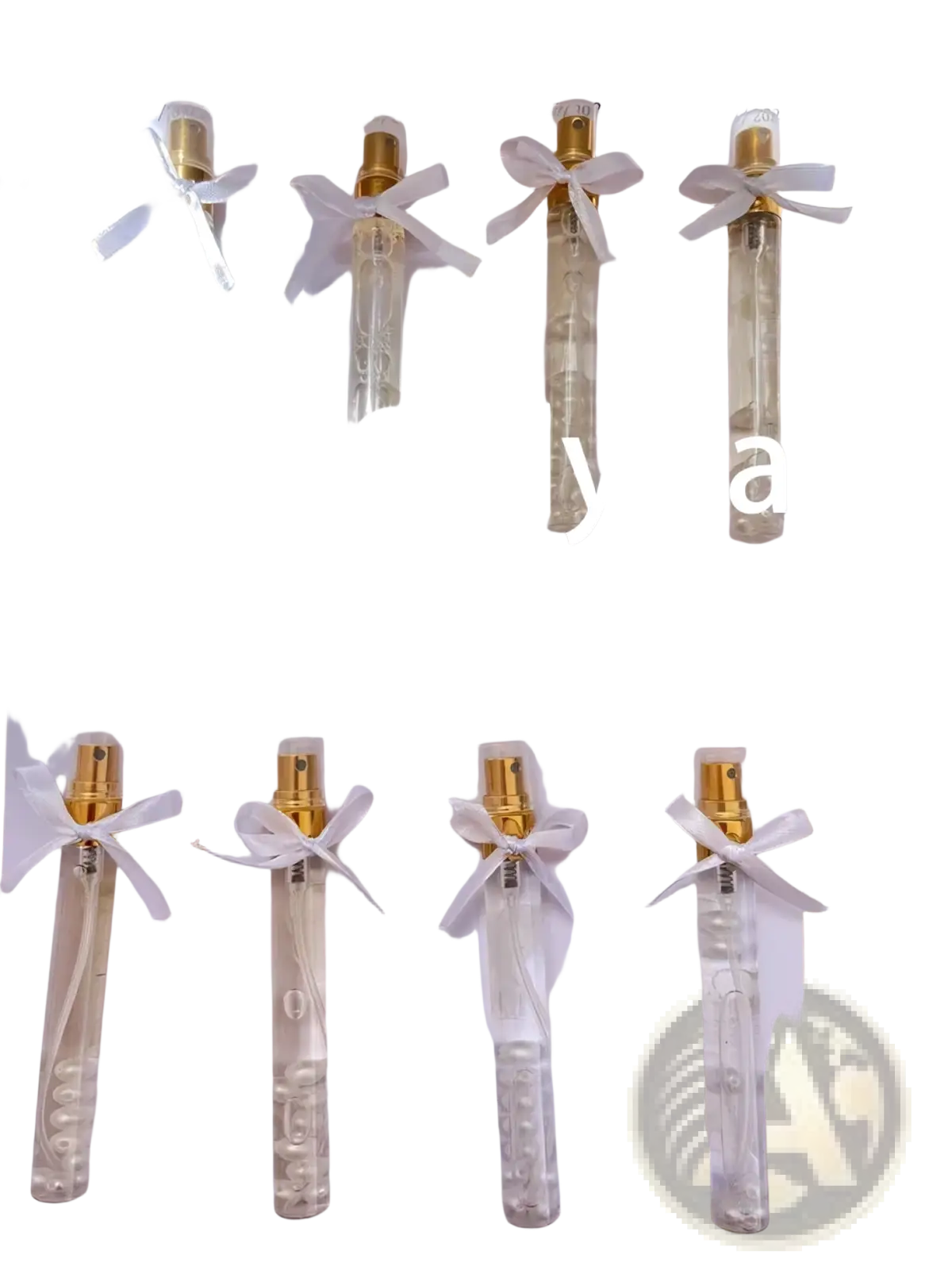Clear glass custom wedding perfume gift vials with gold spray nozzles and white ribbons tied around the neck
