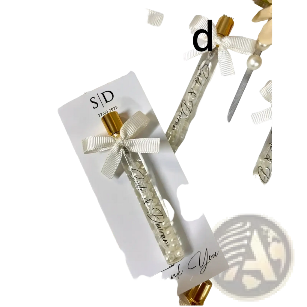 Elegant clear glass custom wedding perfume vial with gold cap and white ribbon containing tiny pearl-like beads