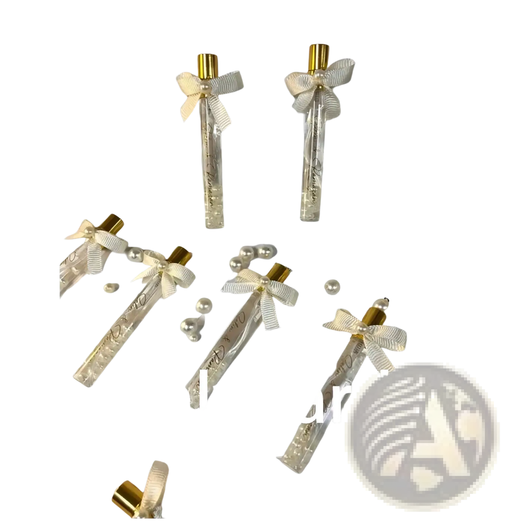 Elegant gold-tipped glass perfume vials with cream ribbons and pearls in white card holders for custom wedding favors