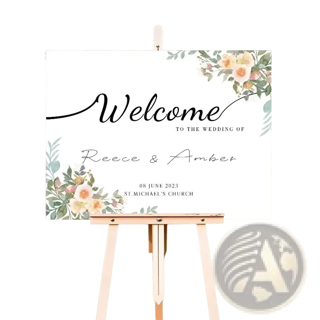Custom wedding welcome sign with delicate peach and pink floral watercolor accents on white board displayed on light wood easel