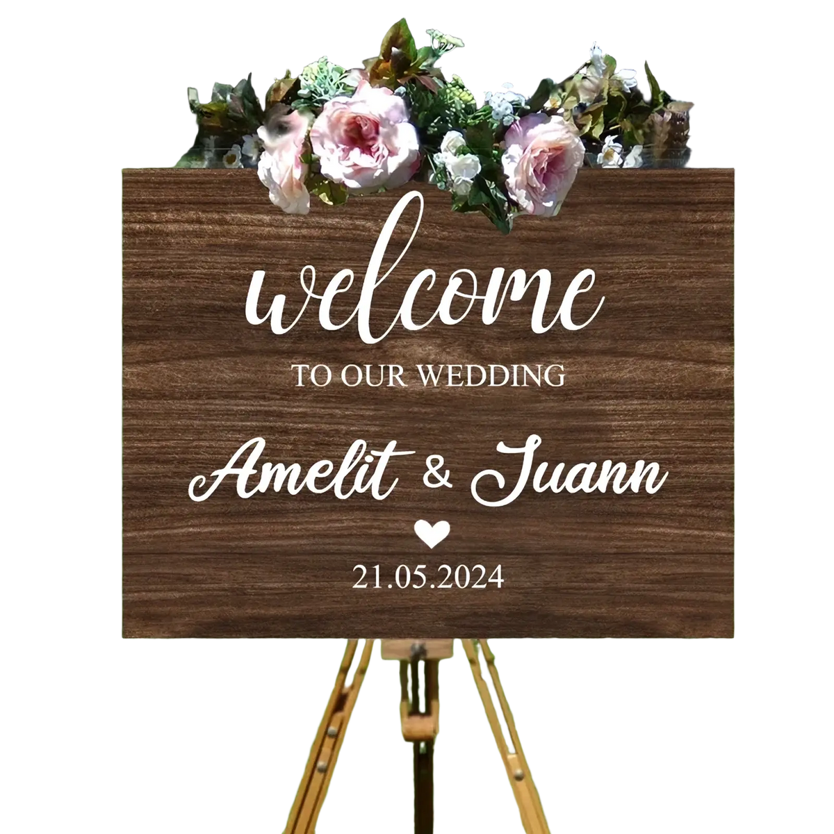 A custom wedding welcome sign made of foam board with rustic wood texture, white cursive lettering, and pink flowers