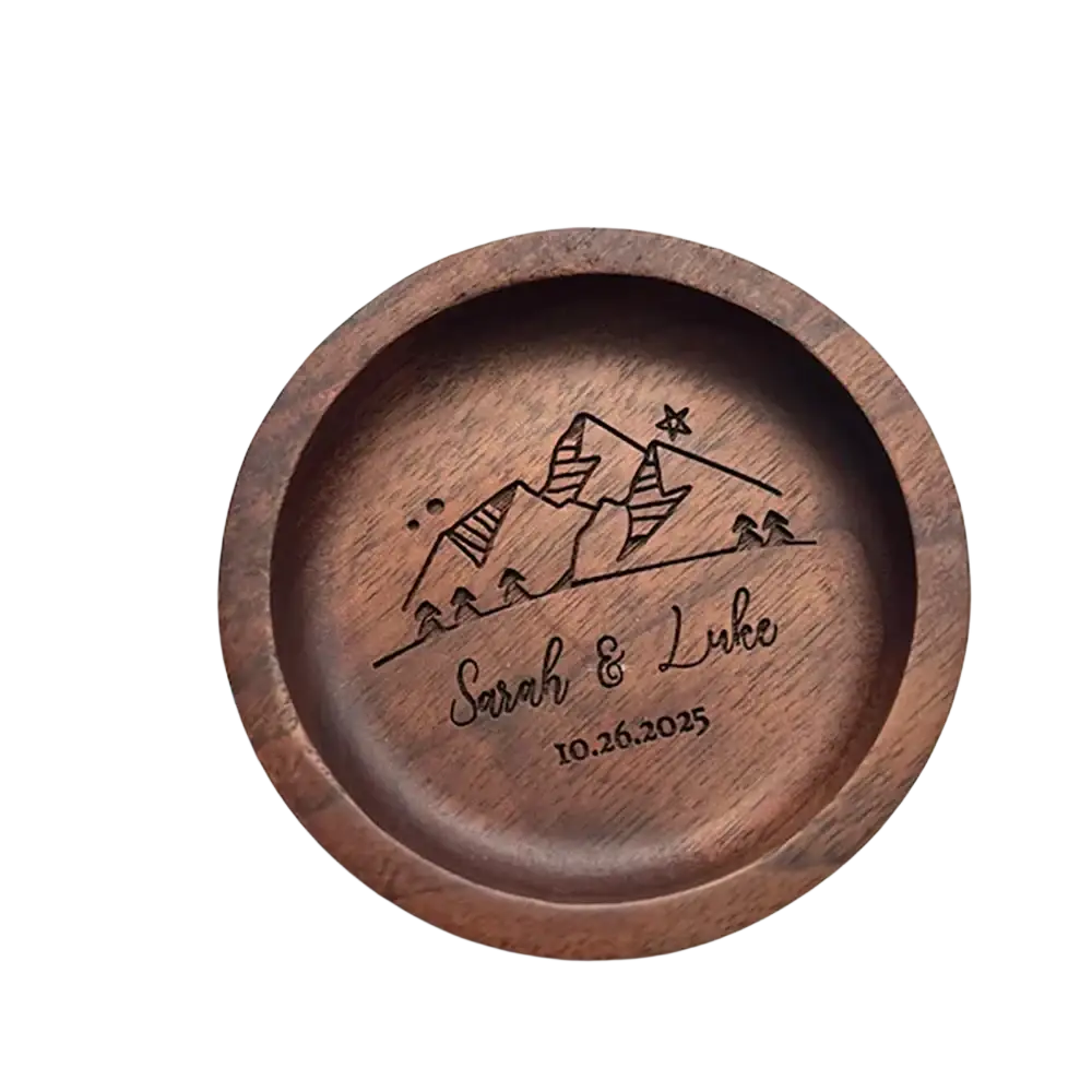 A round dark brown wooden custom wood ring dish with laser engraved mountain landscape names sarah and luke date 10.26.2025