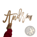 Custom wooden baby name sign in light-colored wood with the name Andrew in flowing cursive for nursery wall decor
