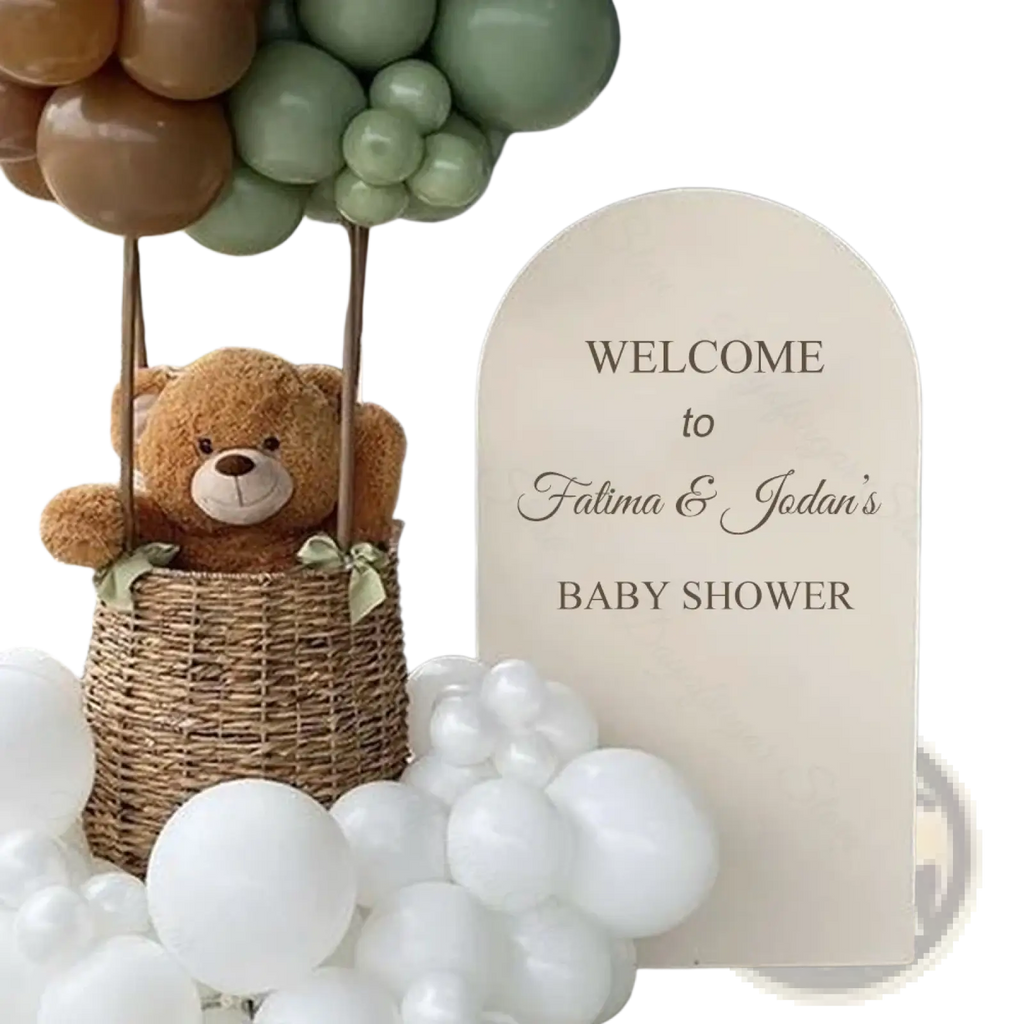 Cream-colored customized arch backdrop board with elegant black cursive lettering for baby shower welcome sign