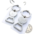 Silver heart-shaped metal bottle openers with engraved wedding details and rings attached to keychains as favors