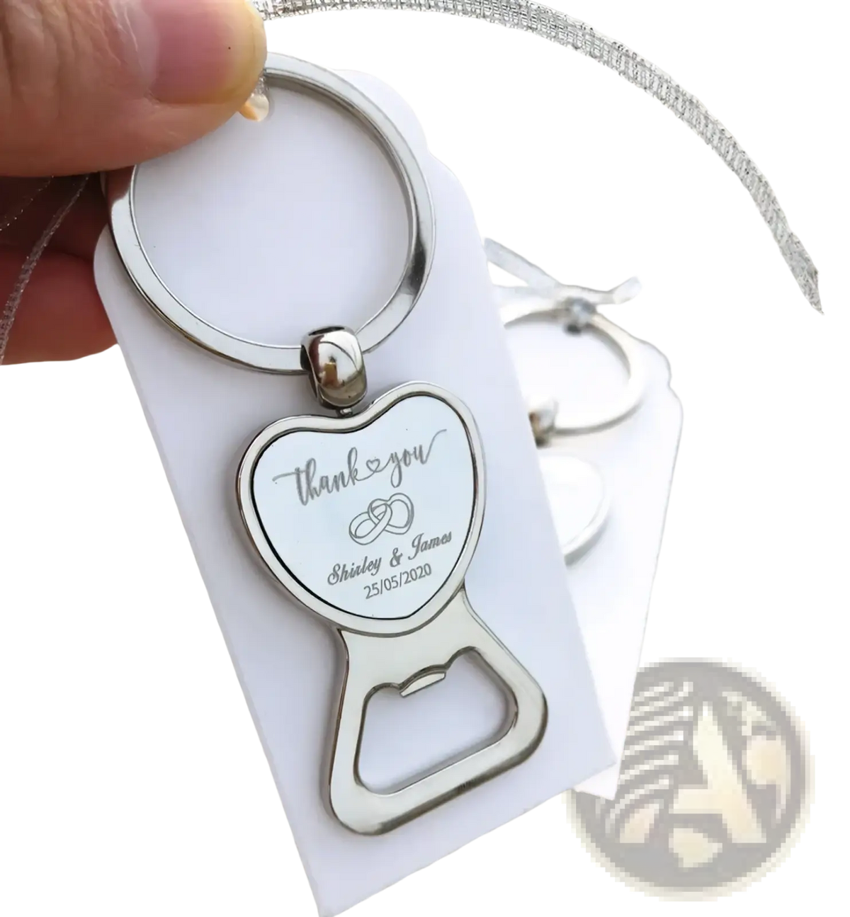Silver heart-shaped metal bottle opener keychain engraved with thank you message and wedding details for favors