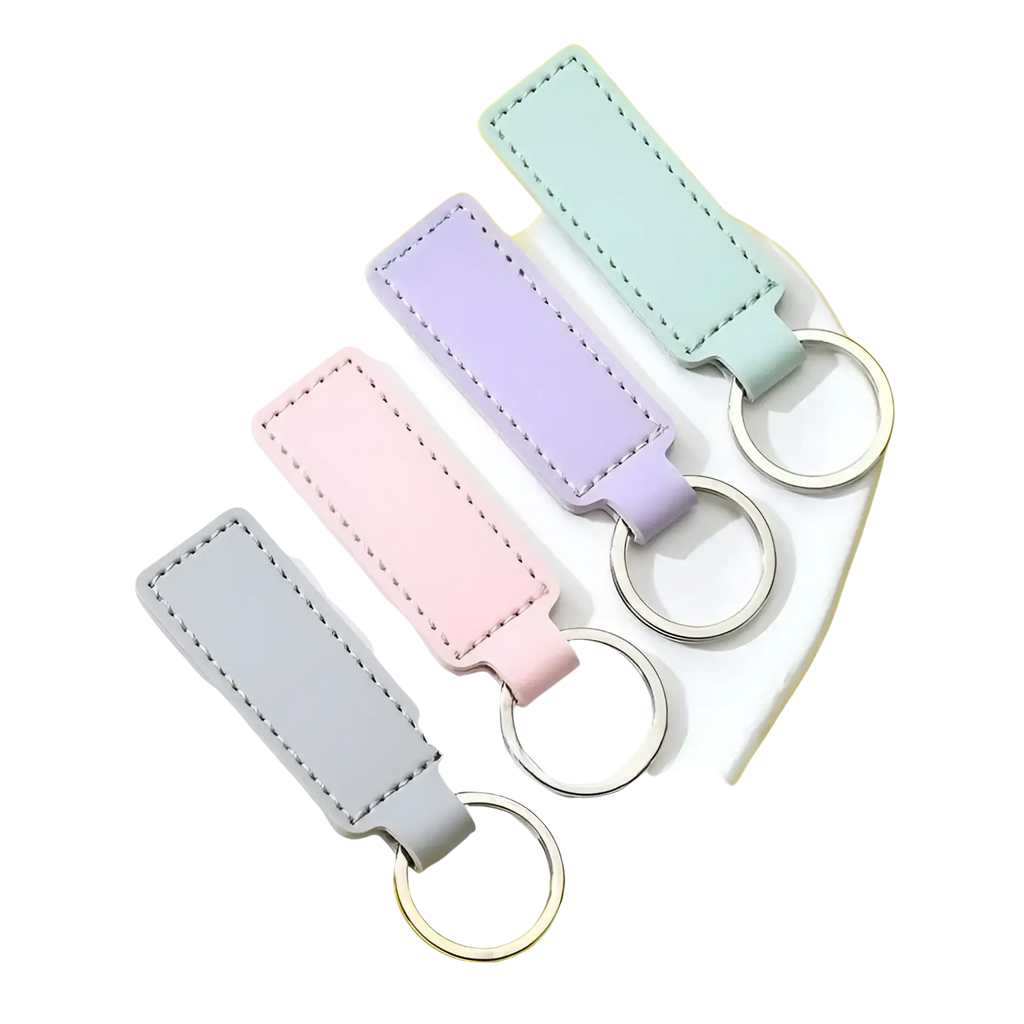 Customized leather keychain set featuring pastel-colored rectangular leather keychains with stitched edges and metallic rings