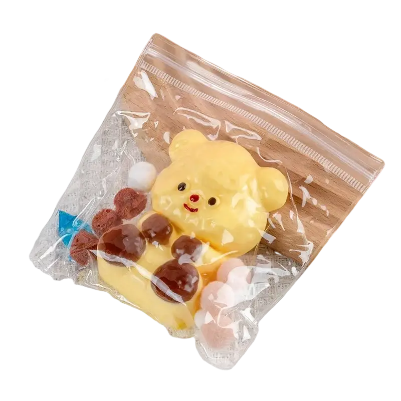 Yellow bear-shaped silicone squishy toy with brown and pink accents in clear bag for sensory fidget stress relief