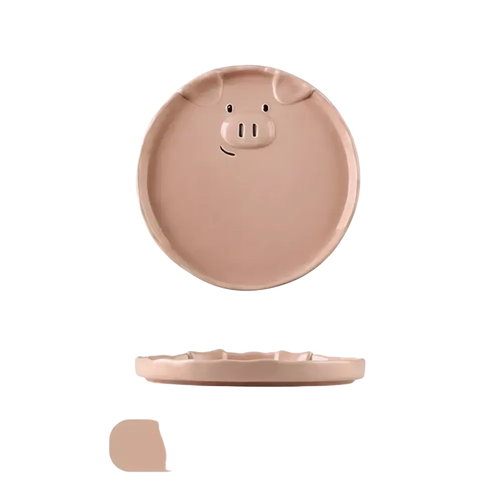 A pink ceramic plate with a cute pig face design featuring small ears and a smiling snout from the cute pig ceramic dinnerware set
