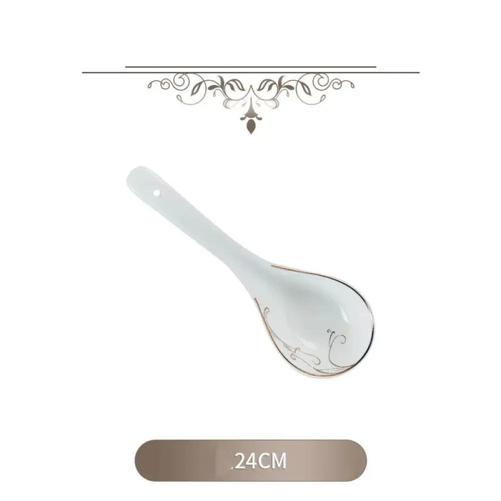 A delicate white porcelain spoon with gold leaf floral detailing featured in a classic stainless steel flatware set