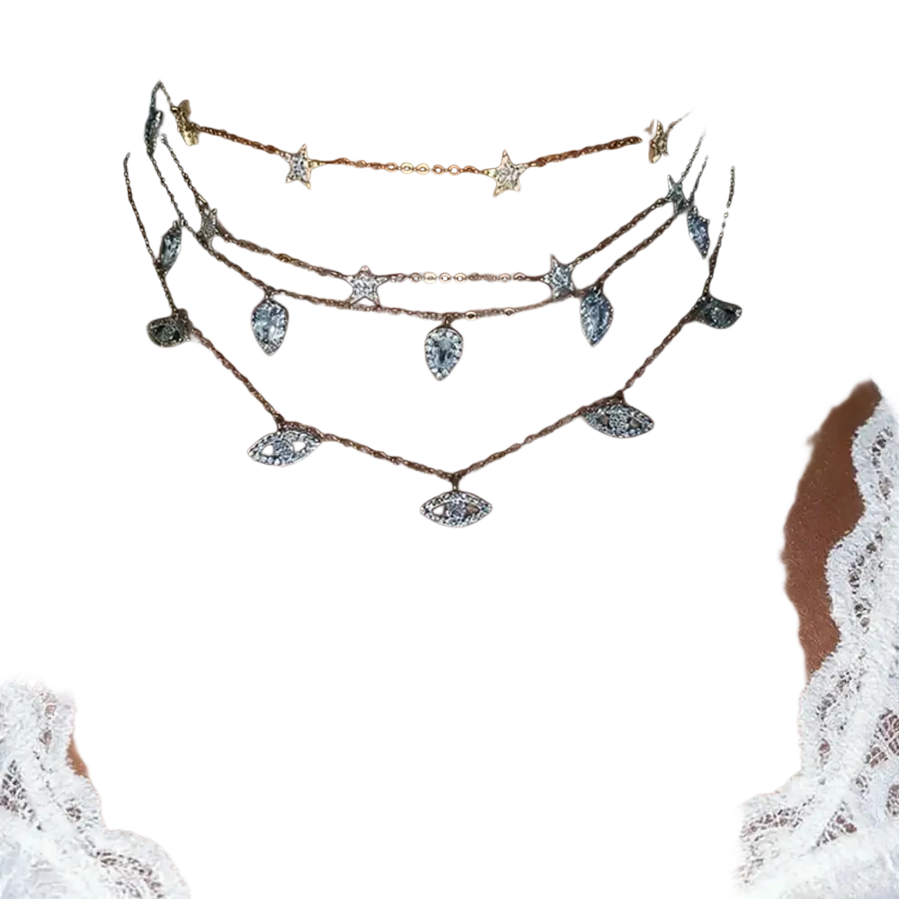 A layered gold-toned cz zircon teardrop choker necklace with sparkling star and eye-shaped charms