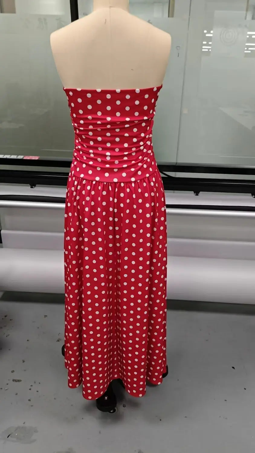 Red strapless maxi dress with white polka dots made of stretchy fabric featuring an off shoulder design.