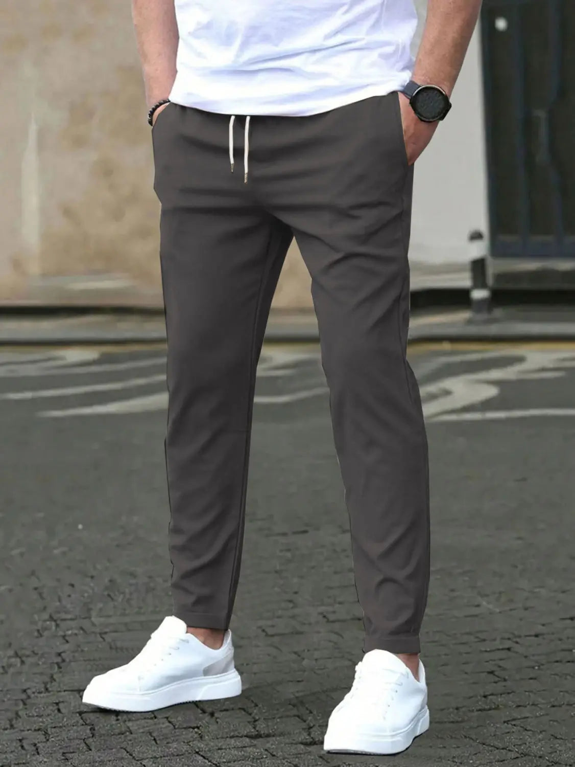 Slim fit tapered jogger pants in dark gray with white drawstrings and a sleek modern design.