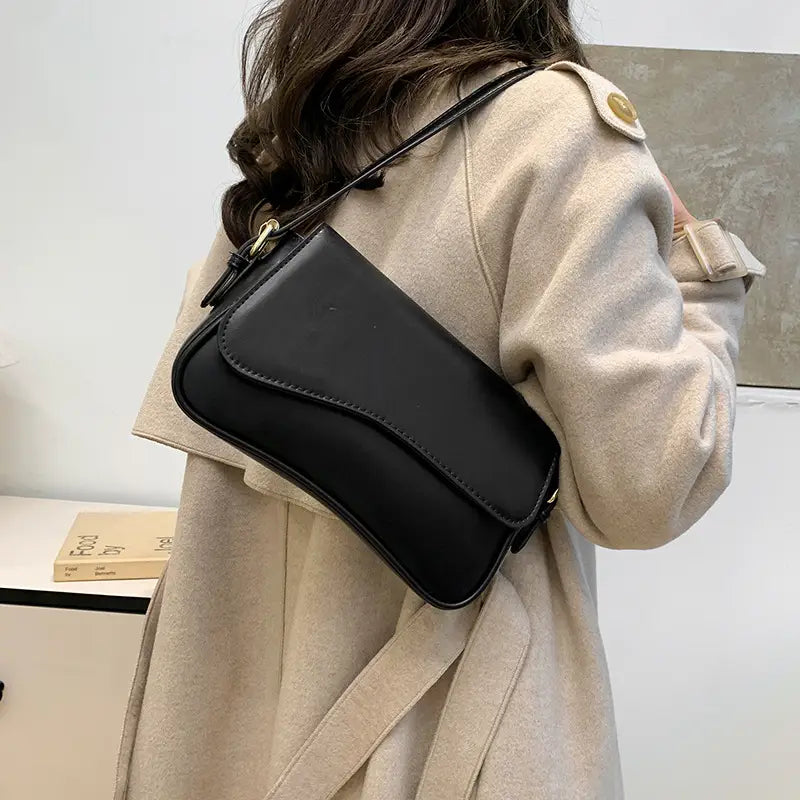 black leather messenger bag with minimalist crossbody design and gold tone hardware for organized daily use