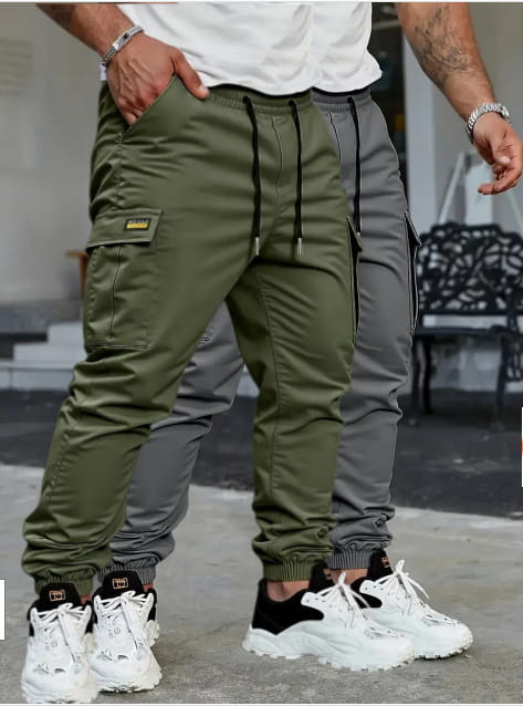 Men’s slim fit cropped cargo joggers in olive green with black drawstrings and a small yellow logo patch on the thigh.