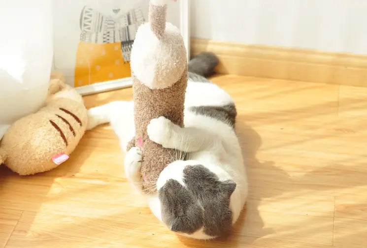 Ein Plüsch-Katzenkissen zur Nackenunterstützung und Gelenkentlastung mit weichem weiß-grauem Körper und einer strukturierten braunen Basis.