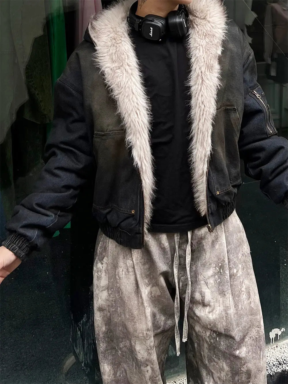 男性用ダメージ加工デニムフード付きウィンタージャケットの一部として用いられた、淡いライトグレーのフェイクファー襟付きブラックボンバージャケット。