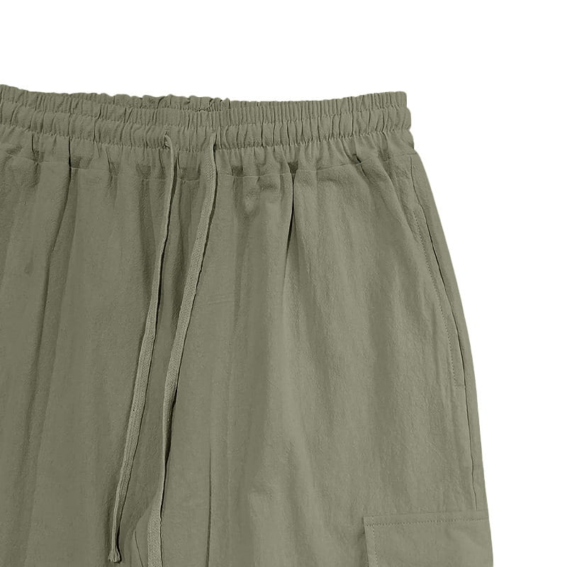 Olive green men linen cargo pants with drawstring waist cuffed ankle and visible side pockets in a relaxed fit.