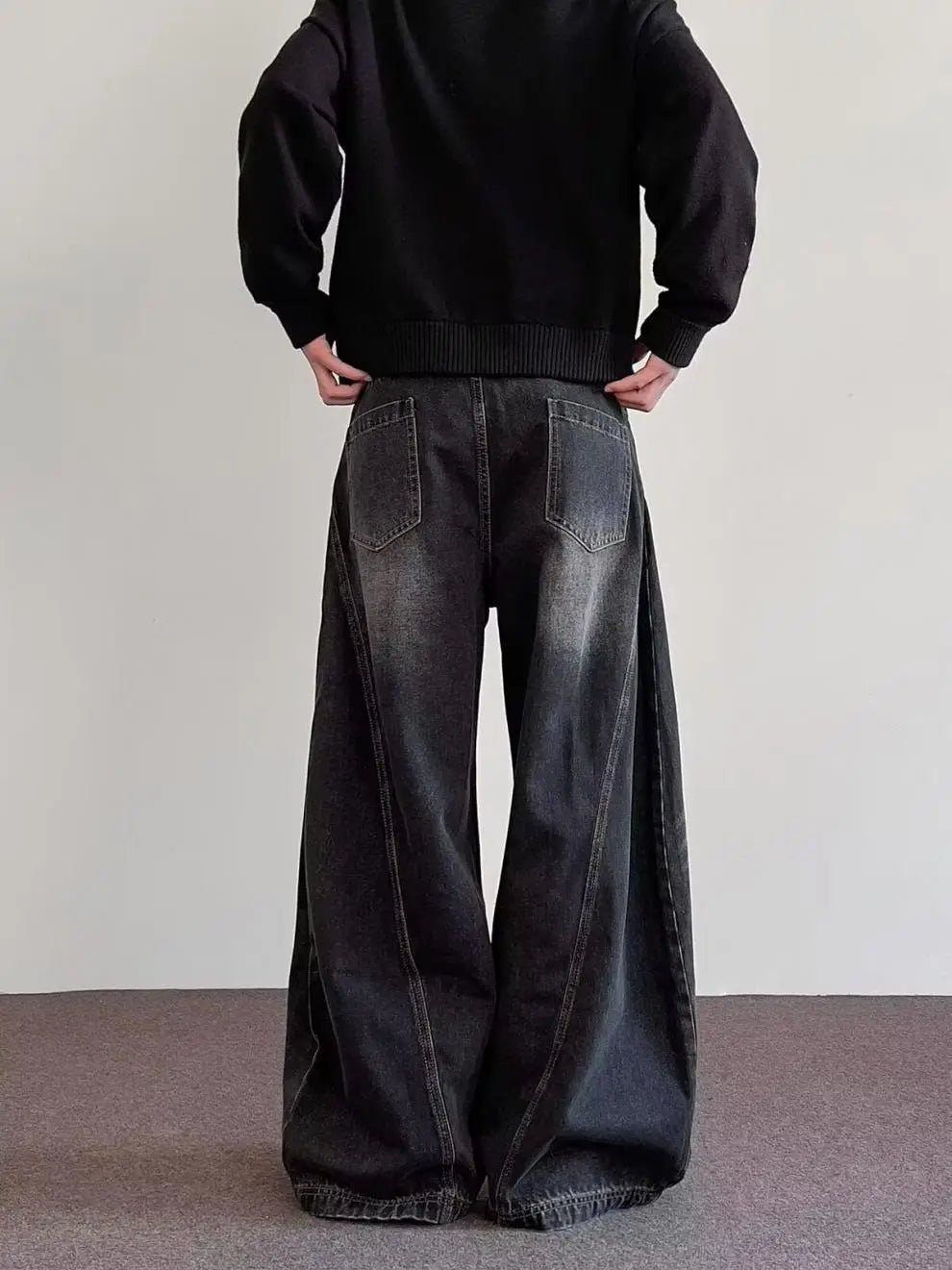 Men’s premium relaxed wide leg denim jeans in black with a faded distressed finish and visible stitching.