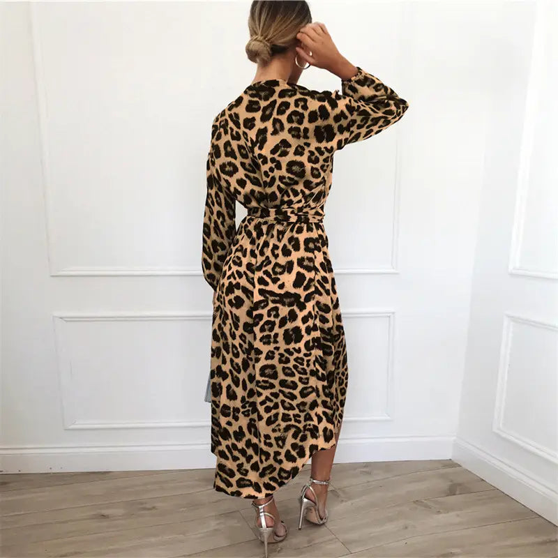 A long-sleeved belted leopard print chiffon wrap dress in tan and black with a v neck.