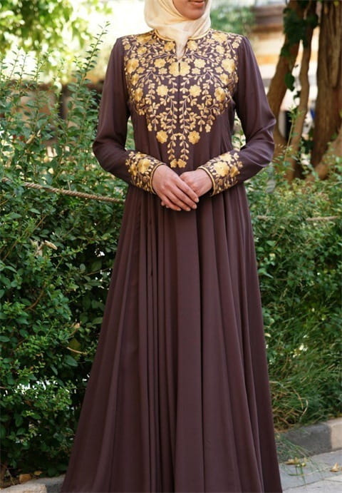 Robe abaya en coton beige à manches longues et de longueur jusqu’au sol, avec une broderie florale dorée complexe sur le buste et les poignets.