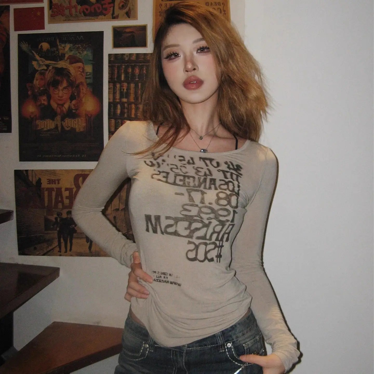 beige long-sleeved crop top with black graphic letter print made from soft fabric for casual wear