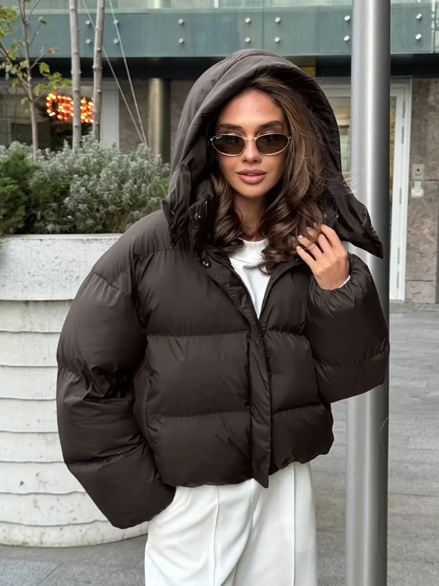 Schwarze wattierte Pufferjacke mit Kapuze aus isolierendem Material mit wattiertem Design für Wärme und Outdoor-Einsatz