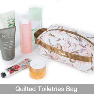 une trousse de toilette matelassée à motif floral pour femmes, avec une sangle brune et une quincaillerie à tons dorés, pour les voyages.