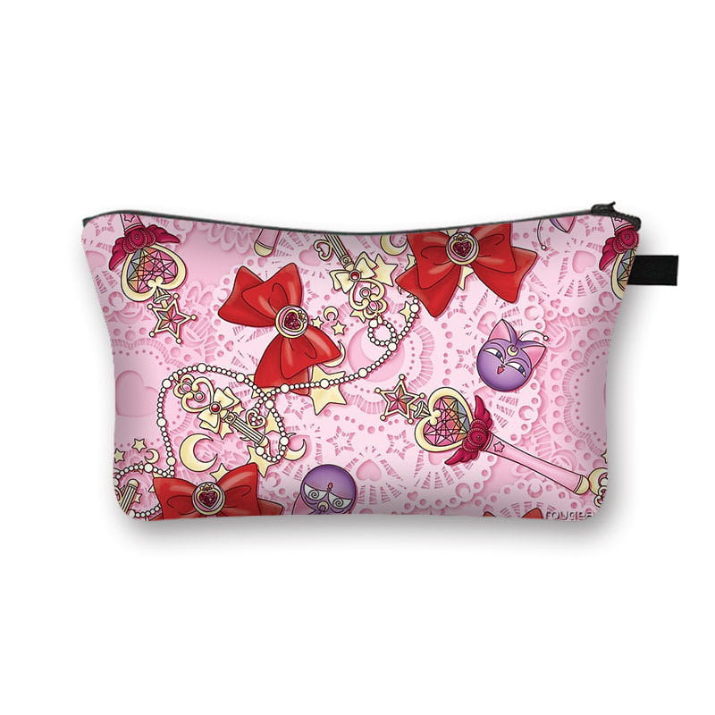 Pink cosmetic bag with a vibrant pattern of red bows, golden crescent moons, and purple sailor moon anime cat faces designed as a whimsical bow and lace travel clutch.