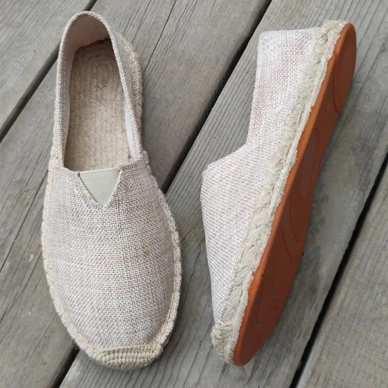 Beige men’s canvas espadrille slip on summer shoes with a woven jute upper and braided rope detailing along the sole.