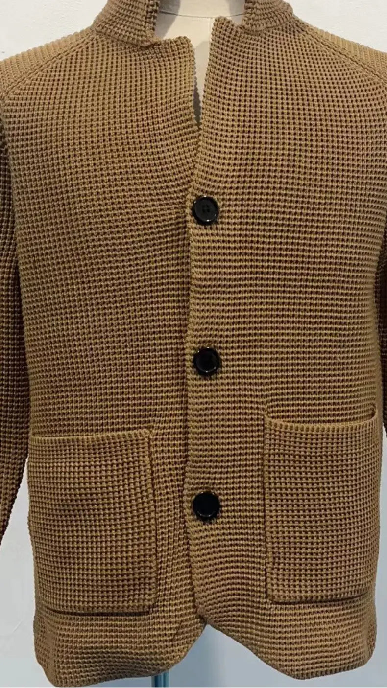 Pull-over en cardigan tricoté pour homme à col montant, en tissu gaufré beige, avec boutons noirs et deux poches avant.