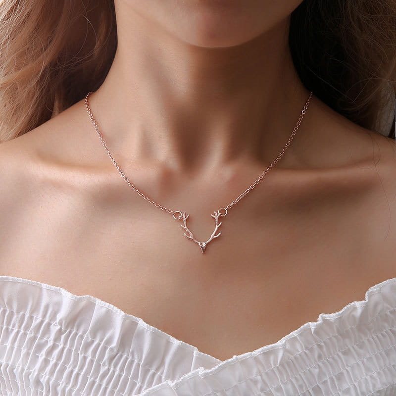 A delicate rose gold antler necklace featuring a small gemstone at the center, designed as a gold antler gemstone pendant clavicle necklace.
