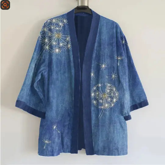 Una chaqueta kimono de mezclilla azul para hombre con bordado intrincado de dientes de león blancos y dorados.