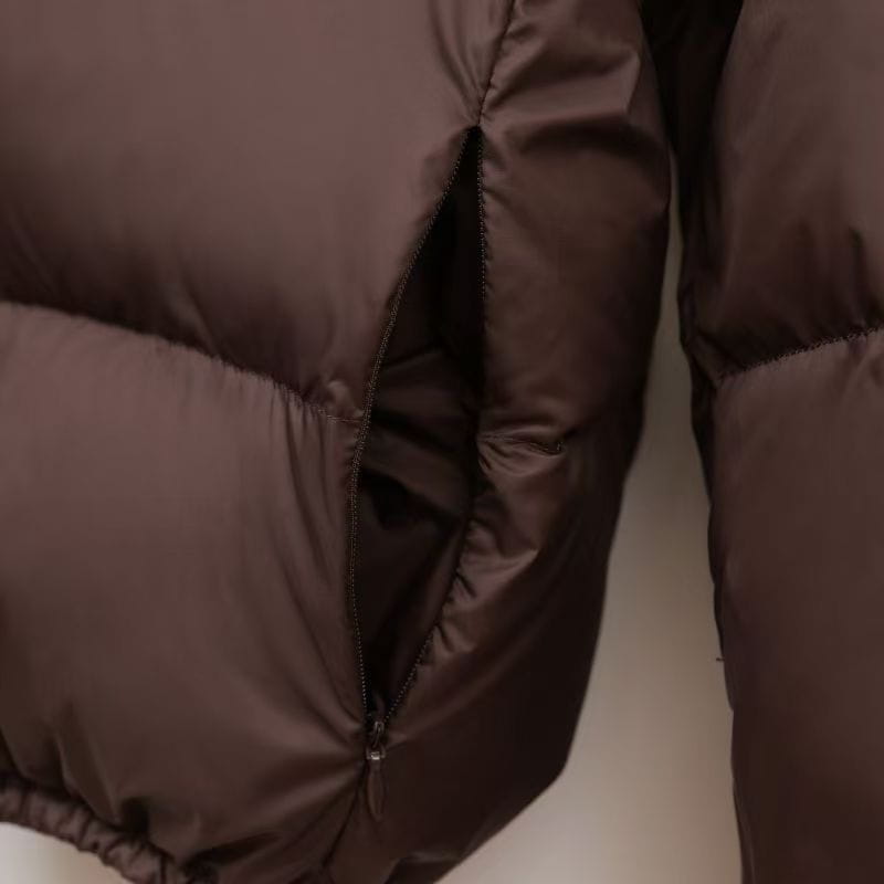 Dunkelbrauner wattierter Steppmantel mit Ziersteppdetails und Reißverschlussverschluss, entworfen für warme Winterkleidung.