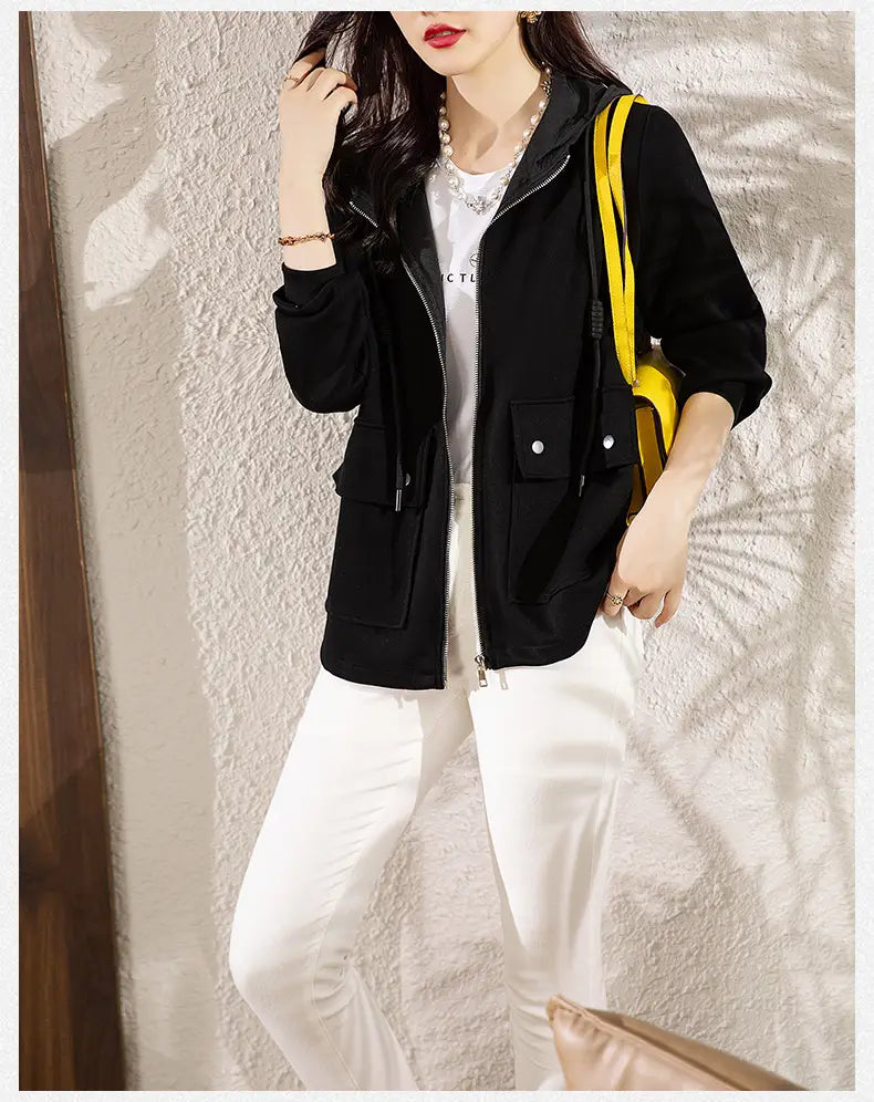 Schwarze Kapuzenjacke mit vorderem Reißverschluss, zwei seitlichen Taschen mit Knopfverschlüssen sowie mit einem Kordelzug an der Kapuze, dargestellt als Produktalternative zur beigen Kapuzen-Cropped-Jacke.