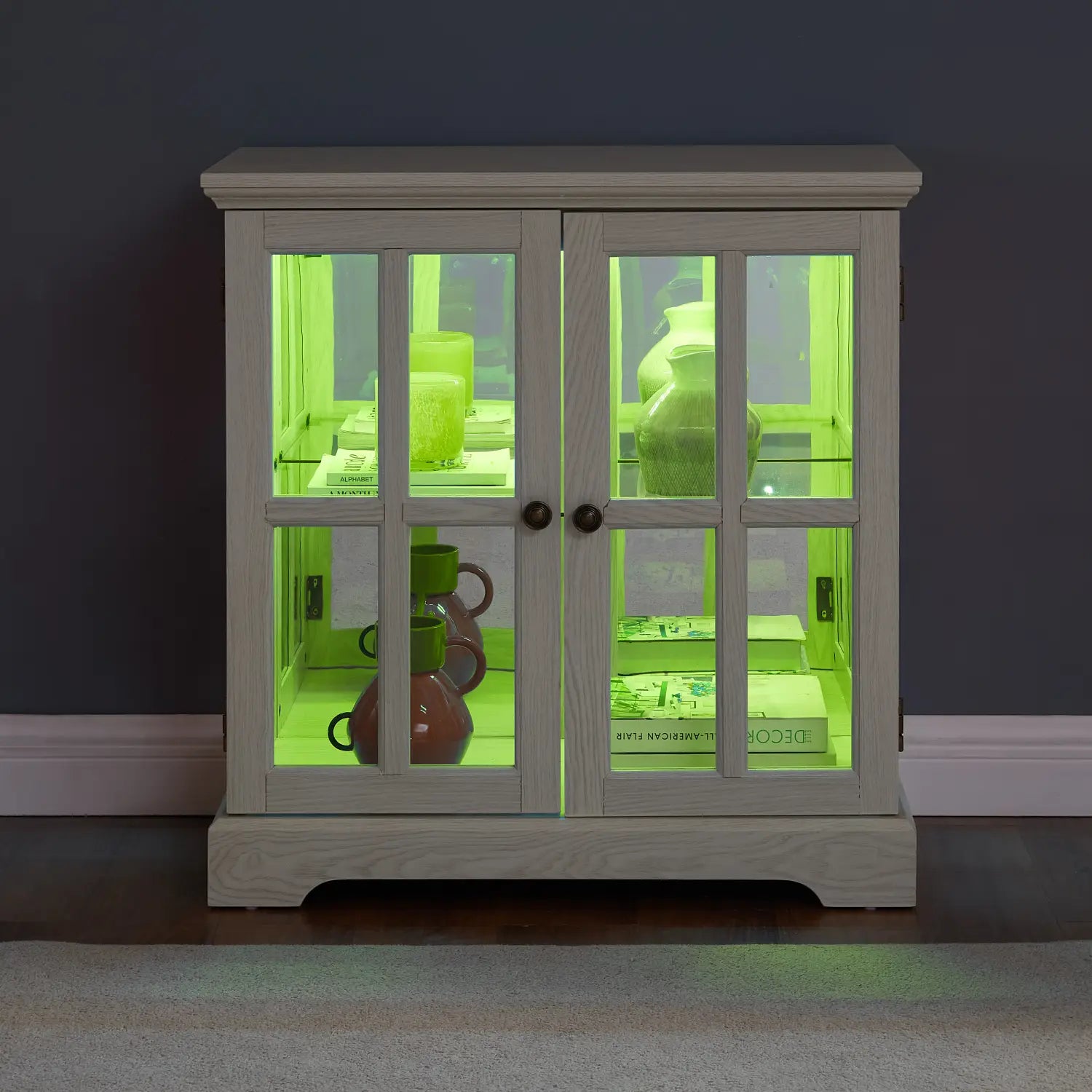 led curio display cabinet with lattice doors in white wood featuring glass doors and green interior led illumination.