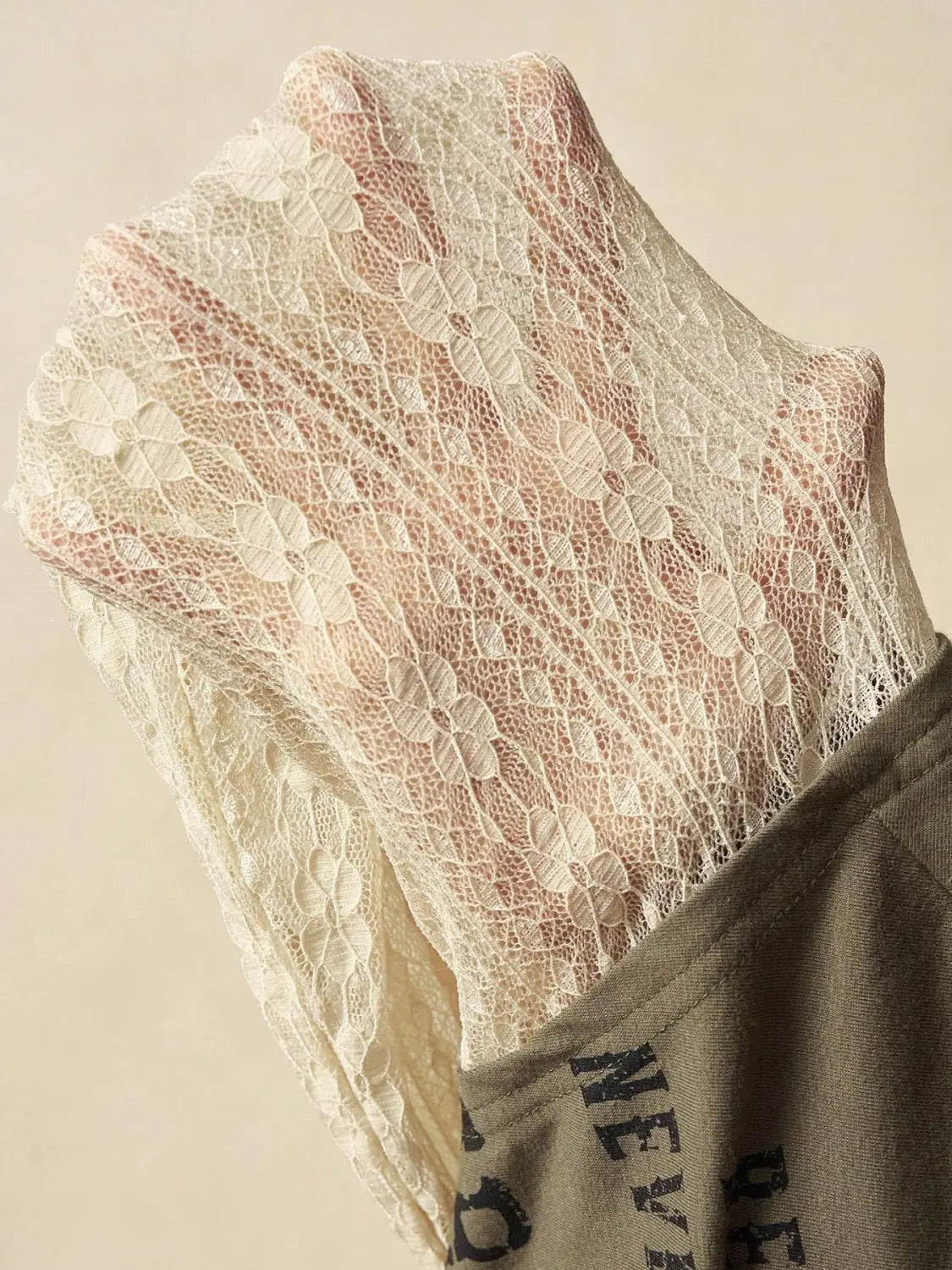 A delicate off-white lace layer off shoulder knitted top with intricate floral and leaf patterns and a sheer semi-transparent texture.