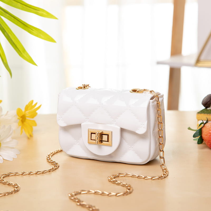 White quilted mini crossbody bag for women with pearl accents and gold-tone chain strap and clasp.