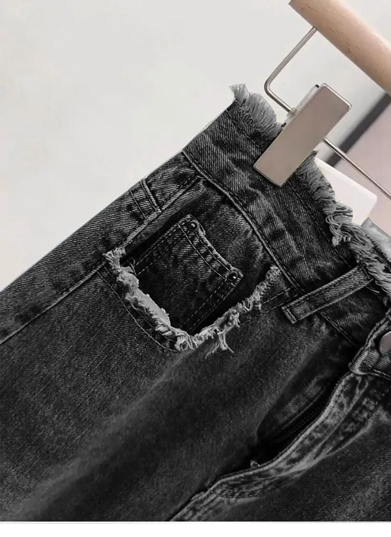 Jupe midi en denim délavé à bord brut dans un denim gris foncé, présentant un ourlet effiloché et un détail de poche dégradée sur le côté arrière.