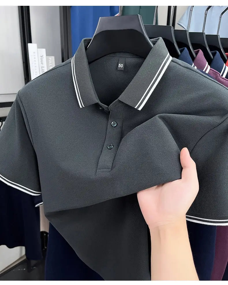 Dunkelgraues mercerisiertes Baumwoll-Poloshirt mit weißem Besatz am Kragen und an den Bündchen der Ärmel, für den Sommer konzipiert, locker und atmungsaktiv.