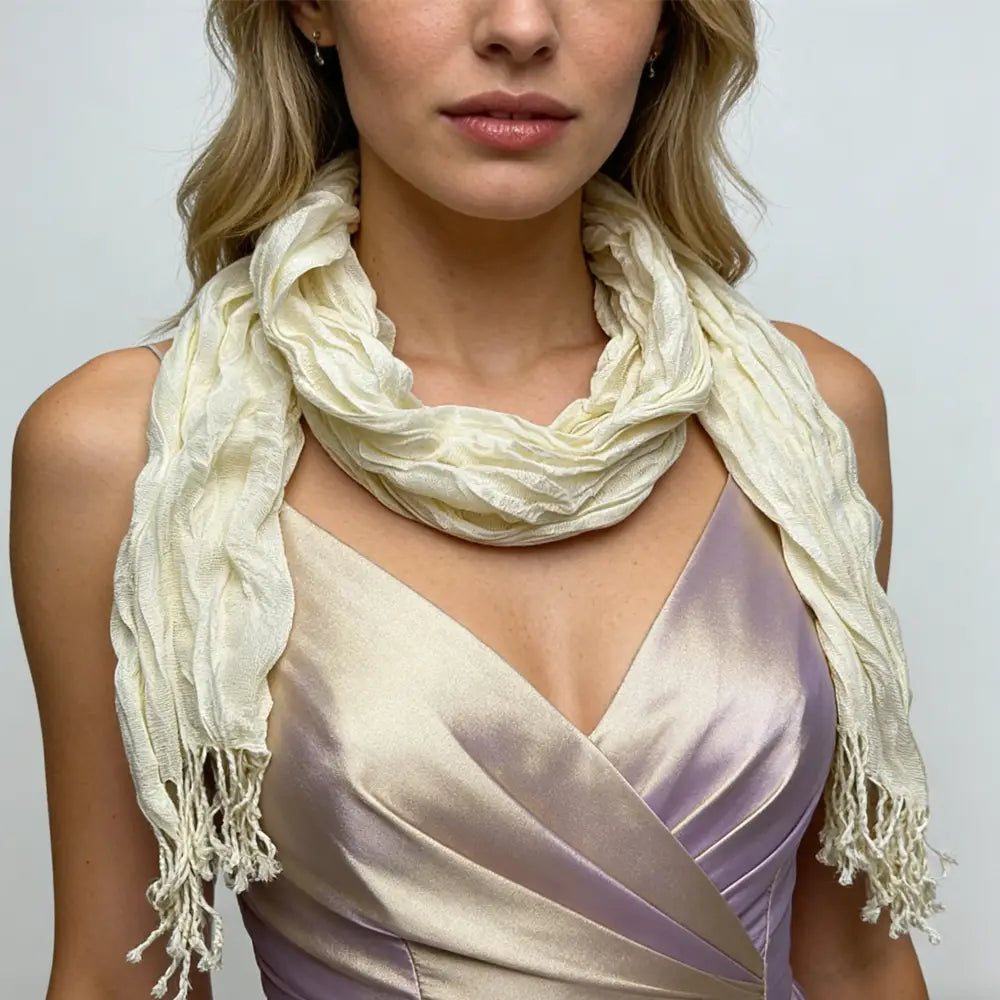 Ein weicher off-white leichter weißer Crinkle-Schal mit einer texturierten Webstruktur und fransigen Enden, perfekt als Sommeraccessoire.
