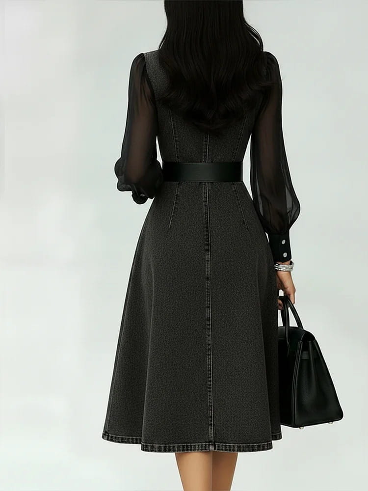 Ein schwarzes Midikleid aus Denim mit transparenten langen Ärmeln und einem passenden Gürtel in einem Color-Blocking-Design für transparente Ärmel.